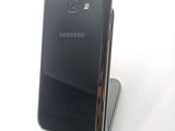 a black samsung phone sitting on top of a stand