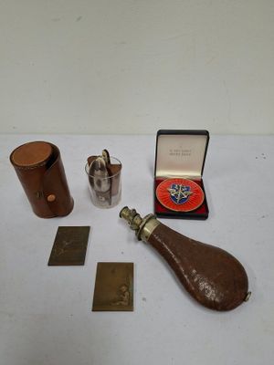 a small bottle, a lighter, and some other items on a table