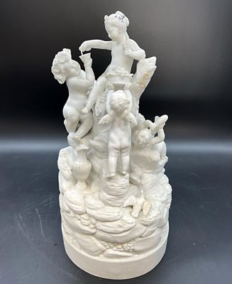 une statue blanche représentant une femme et deux enfants posée sur un gâteau