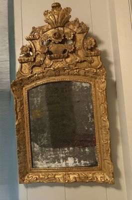 a gold mirror hanging on the wall in a room