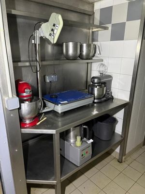 a kitchen with a stainless steel shelf and a mixer on the counter