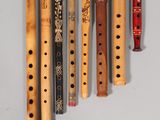 several wooden flutes are lined up against a white wall