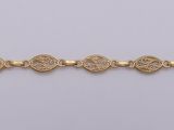 a gold bracelet with an intricate design on a white background