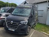 une camionnette noire garée sur un parking à côté d'un immeuble