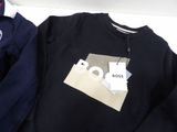 a black sweatshirt with a white tag on it and a blue sweater with a white tag on it