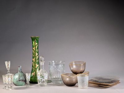 a green vase sitting on a table next to other glassware