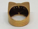 une image représentant une bague en or ornée d'une tête de chat