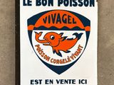 un panneau orange et bleu sur lequel figure un poisson et où l'on peut lire « Le Bon Poisson »