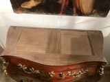 a painting on the wall above a chest of drawers