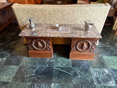 une table en marbre sur laquelle sont posés deux vases, avec un canapé à l'arrière-plan