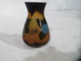 un petit vase posé sur une surface blanche