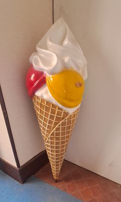an ice cream cone hanging on the wall next to a door