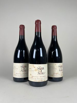 trois bouteilles de vin sont alignées sur une table