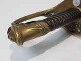 a close up of a gold and black sword on a white surface