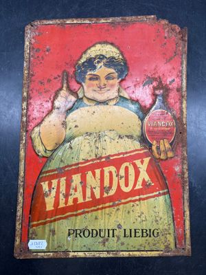 an old tin sign of a woman holding a beer bottle