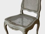 La chaise est en bois et son assise est en osier.