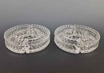 deux cendriers en verre transparent posés sur une table avec un fond noir