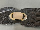 a black leather belt with a gold buckle on it