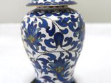 a blue and white vase with a lid sitting on a table