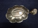a small silver plate with a small silver cup on it