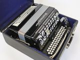a black and silver accordion in a case on a white surface