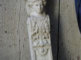 a statue of a woman and a chicken next to a wall