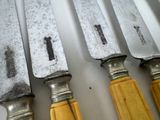 five knives that are lined up on a table