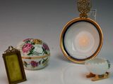 une assiette blanche ornée d'une couronne dorée, à côté d'un œuf et d'un cadre photo