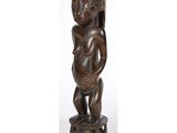 une statue en bois représentant une femme tenant un bébé dans ses bras