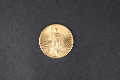 gros plan d'une pièce d'or sur une surface noire