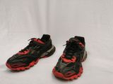 une paire de baskets noires et rouges avec des lacets rouges
