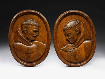 a pair of carved wood plaques depicting a man and a woman