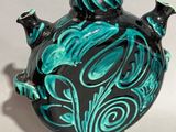 a black and green vase with a green design on it