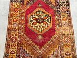 an old rug with a red and yellow design on it