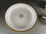 a white bowl with gold trim and a gold rim