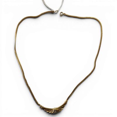 the necklace is made of brass and has a long chain