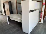 a white desk with a fire extinguisor in the corner