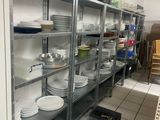 beaucoup d'assiettes et de casseroles sur les étagères de la cuisine