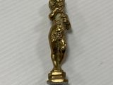 a close up of a gold statue on a white surface