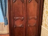 une grande armoire en bois dans le coin d'une pièce