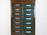 une vieille armoire en bois avec de nombreux tiroirs, surmontée d'autres tiroirs