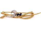 un gros plan d'une broche ornée d'un croissant et de pierres bleues
