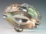 a silver shell shaped object on a white surface