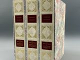 trois livres sont empilés sur une table
