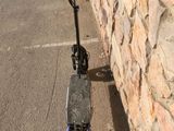 a scooter parked next to a stone wall in a parking lot