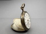 a silver pocket watch sitting on top of a table