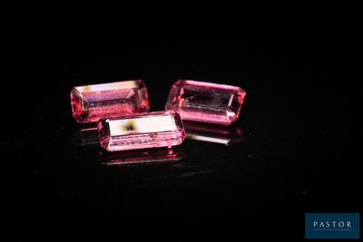 deux cubes de cristal rose posés sur une surface noire
