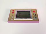 a pink and gold game console on a white surface