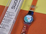 une montre posée sur une table à côté d'une boîte en plastique