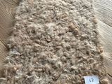 un tapis en laine posé sur une table en bois, avec une étiquette de prix dessus